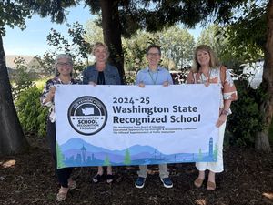 3 principals and a superintendent holding a banner